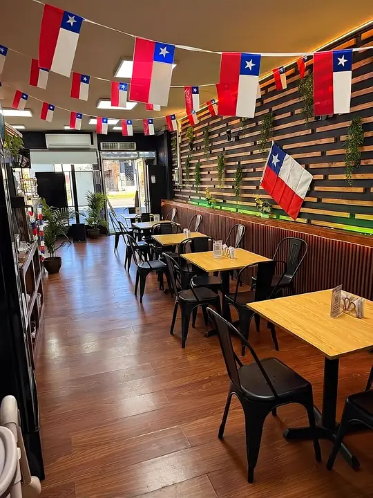 Salón de Tú Sello Premium en República 420, con mesas de madera y muro de listones con plantas